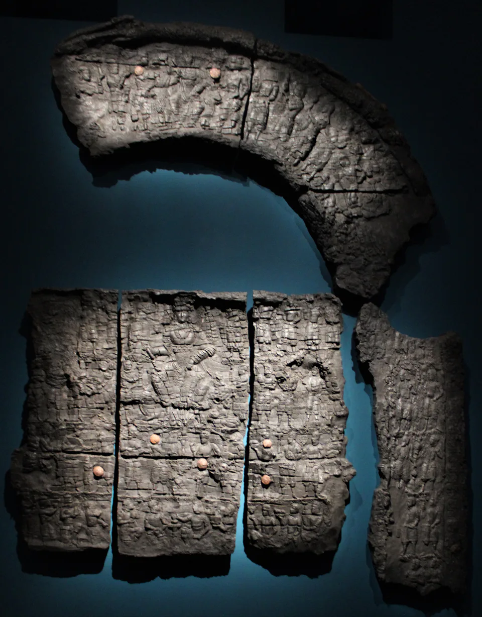 Overall view of the remains of the Kafir-Kala gate, with carved decoration centered on the goddess Nana. Charred wood. Samarkand, Uzbekistan, 6th century.