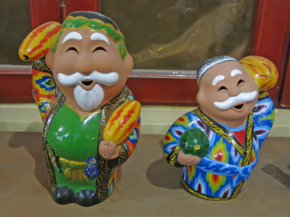 Picture showing two smiling men figures in Rixtan, Uzbekistan