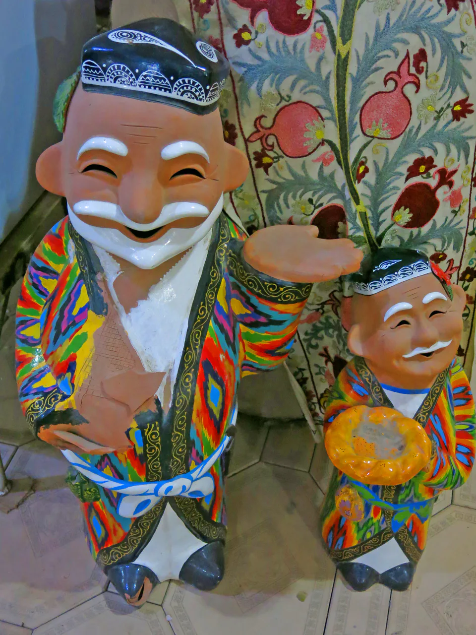 Picture showing two statues of smiling men in Rixtan, Uzbekistan