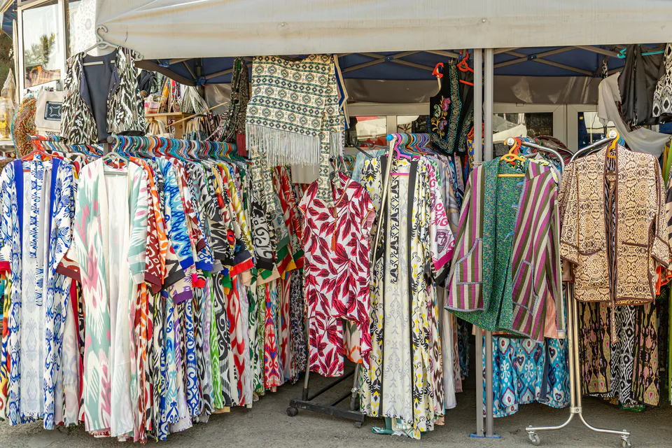 People sell robes and other national costumes at the Chorsu market in Tashkent, Uzbekistan, in August 2025.