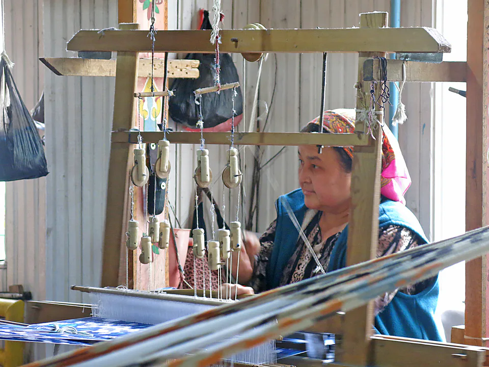 Picture showing a weaveress at work in Yodgorlik Silk Factory, Margilan (Uzbekistan)